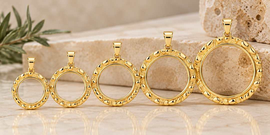 Five US Certified Jewelry yellow gold nugget-style round coin bezels in ascending sizes, displayed empty on a beige stone surface